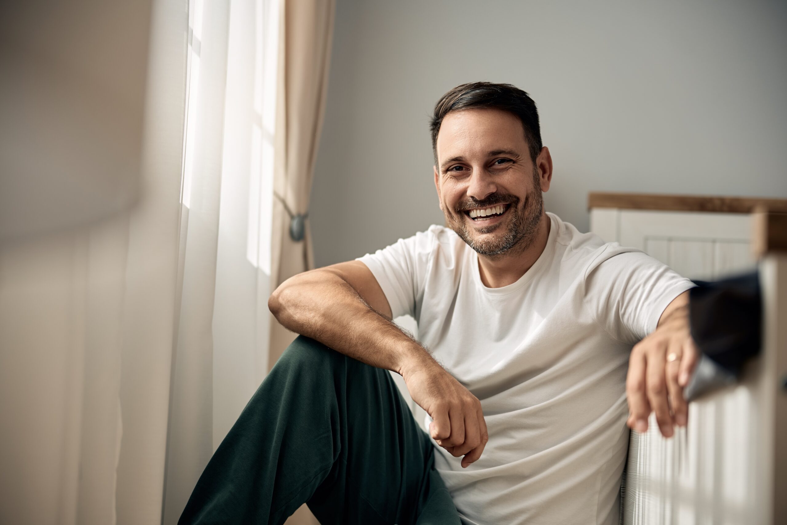 Smiling male in bedroom of a men’s sober living house